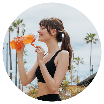 A woman in workout clothes drinking from a BIBIBOP Asian Grill water bottle