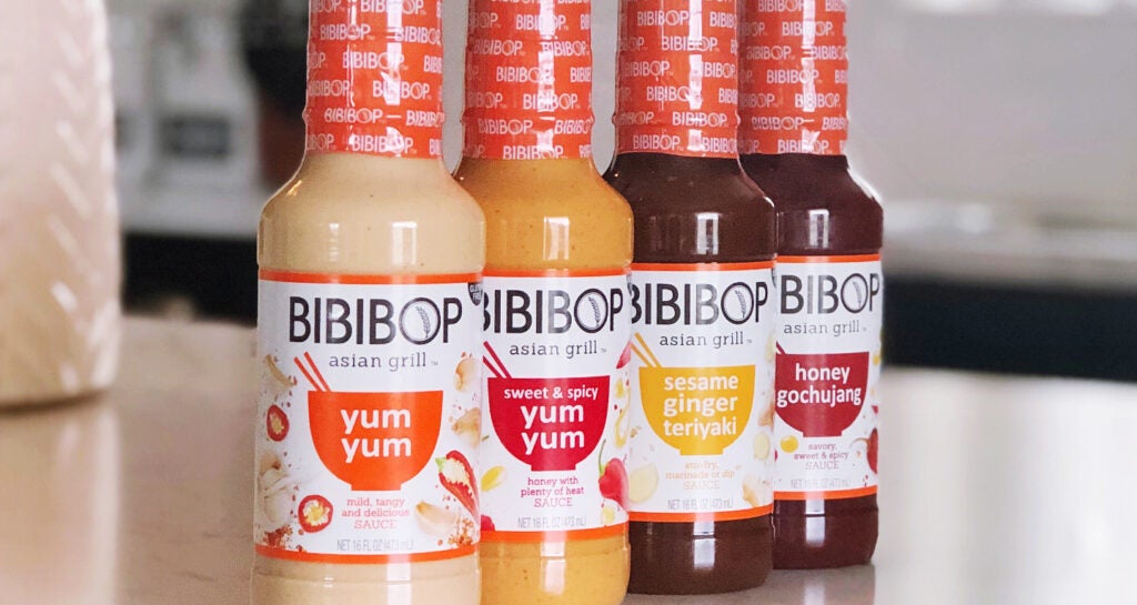 BIBIBOP Asian Grill sauces sitting on a counter: Yum Yum, Sweet and Spicy Yum Yum, Sesame Ginger Teriyaki, Honey Gochujang