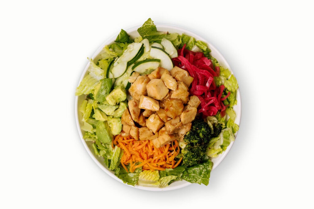 BIBIBOP's Detox Salad with Miso Glazed Salmon, Crispy Romaine, Avocado, Roasted Sesame Broccoli, Pickled Red Onion, Carrots, and Cucumber, finished with Sesame Ginger
