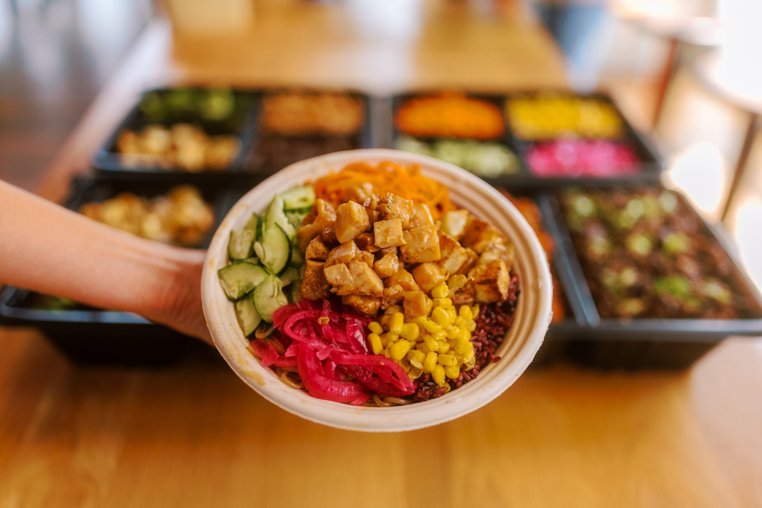 Hand holding bowl of rice and protein