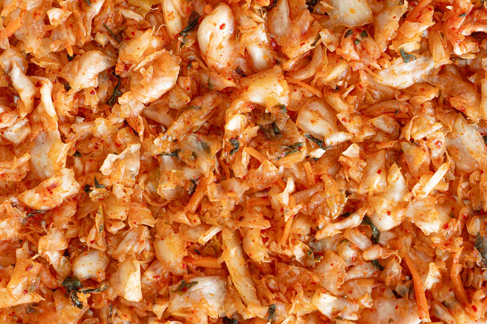 Close up of kimchi showing napa cabbage, shredded carrot, scallion and Korean chili flakes